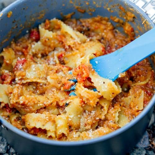 Red lentil marinara and pasta in a backpacking pot with a blue spoon