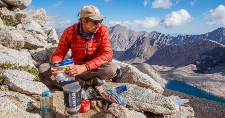 Michael sitting at the top of a mountain pass eating lunch