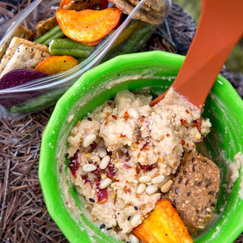 Hummus in a green backpacking bowl on a rock