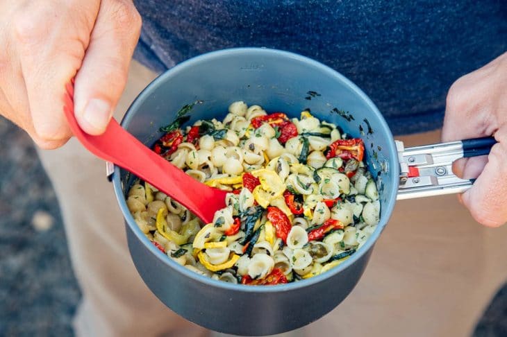 Michael holding a backpacking pot filled with pasta