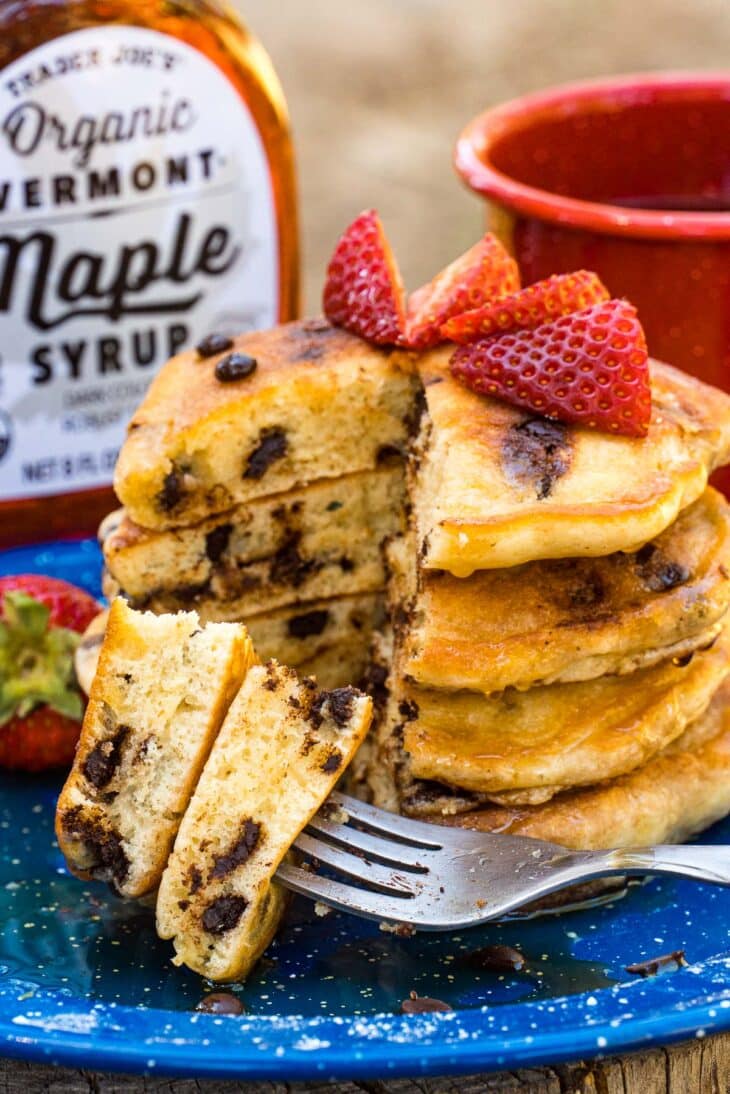 A stack of chocolate chip pancakes with strawberries on top