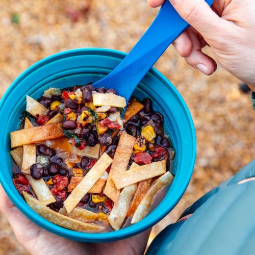 Megan holding a blue bowl of dehydrated tortilla soup