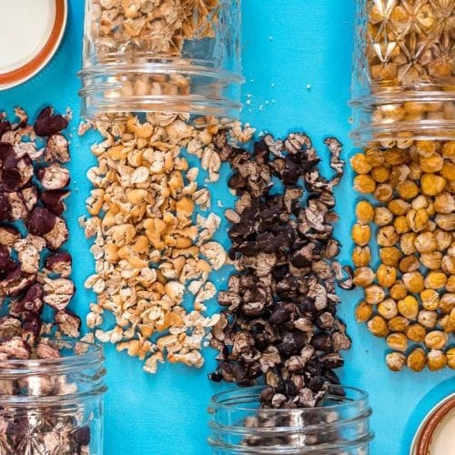 Different types of dehydrated beans spilled out over a blue background