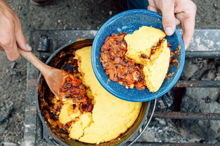 Serving vegetarian chili cooked in a Dutch oven on the campfire