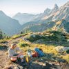 Michael sitting with his backpacking cooking kit and the Cascade mountains in the background