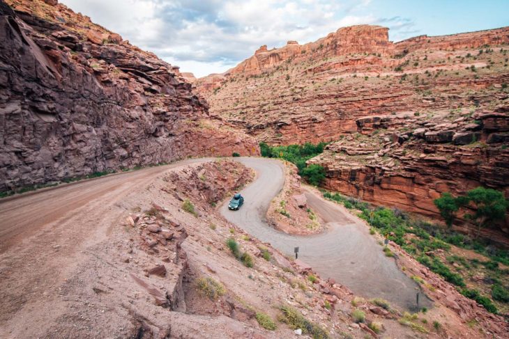 A green car driving on winding switchbacks