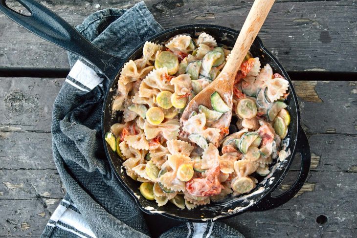 Pasta primavera in a cast iron skillet on a camping stove.