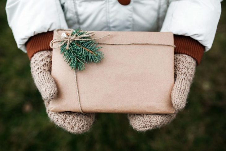 A woman holding a package wrapped in brown paper