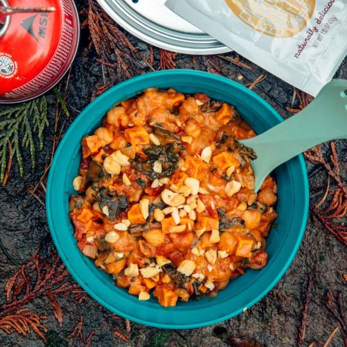 A blue bowl of sweet potato stew on a natural background