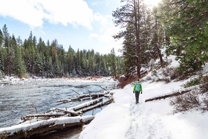 Megan hiking in the snow along a river